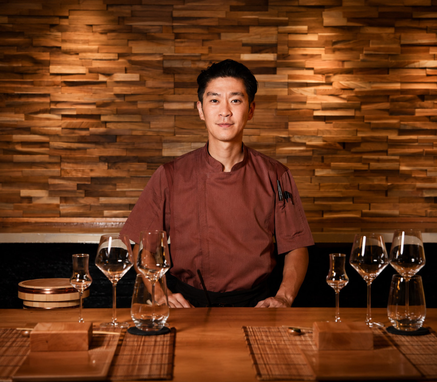 Chef seated at the omakase counter in the original editorial deck